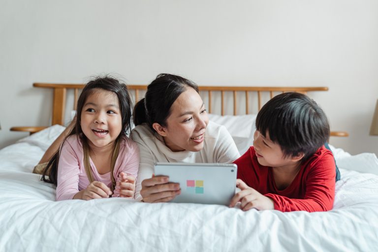 A parent with her two children learning on a tablet